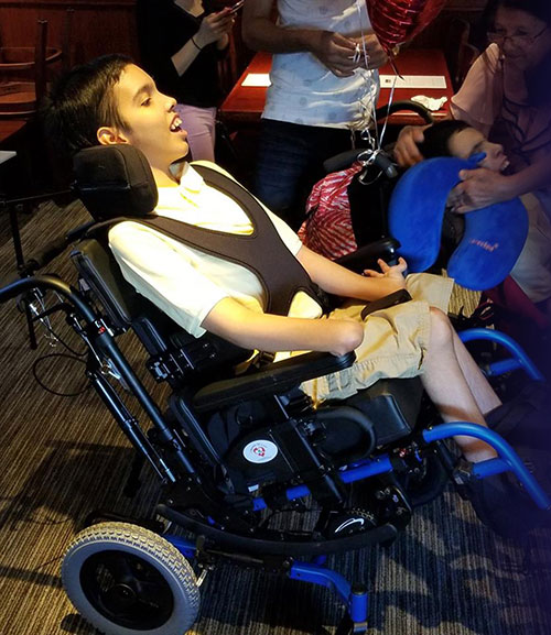 young boy in a blue wheelchair